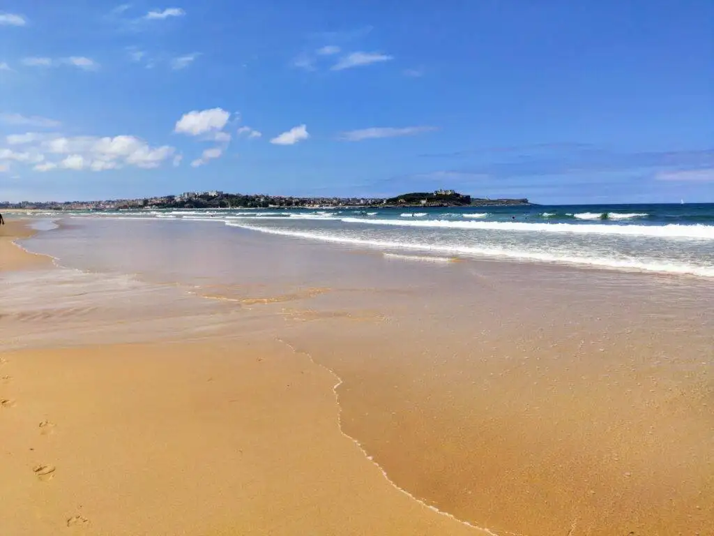 Somo beach and gold sand with waves and blue cloudy sky surf w kantabrii