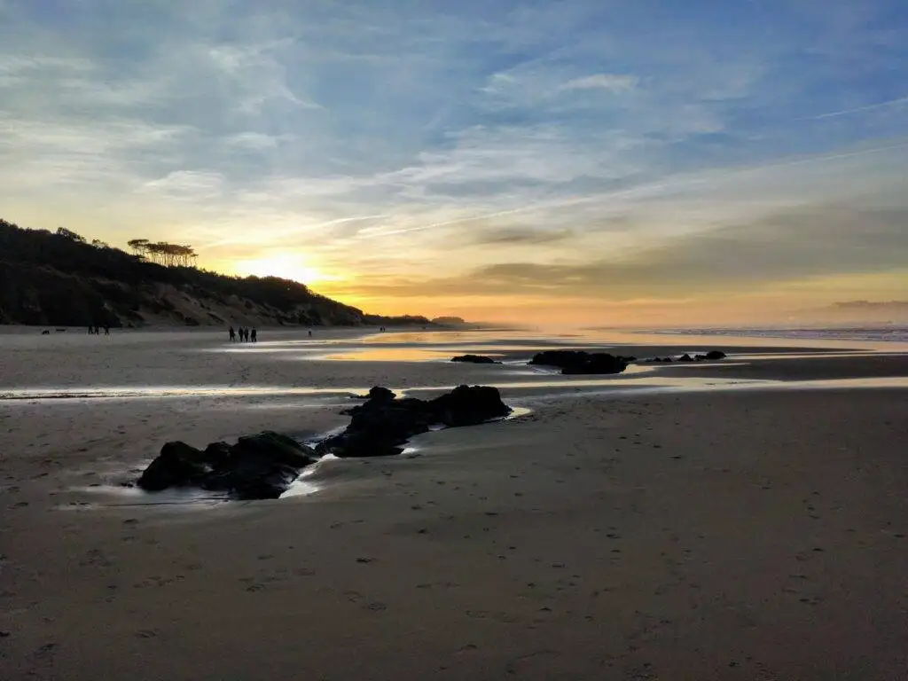 Somo beach during sunset with rocks and clouds surf en Cantabria in surf w kantabrii